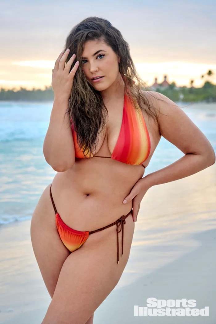 Gigi Robinson stands on the sand in a multi-colored string bikini.